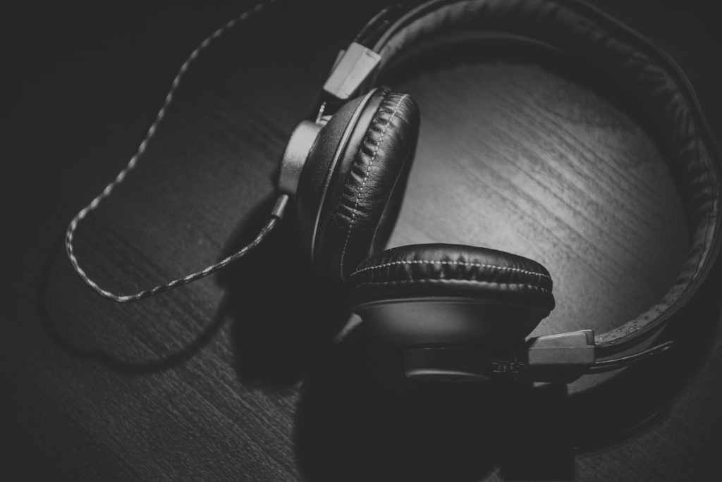 black headphones on a table - overcome wrtiers block